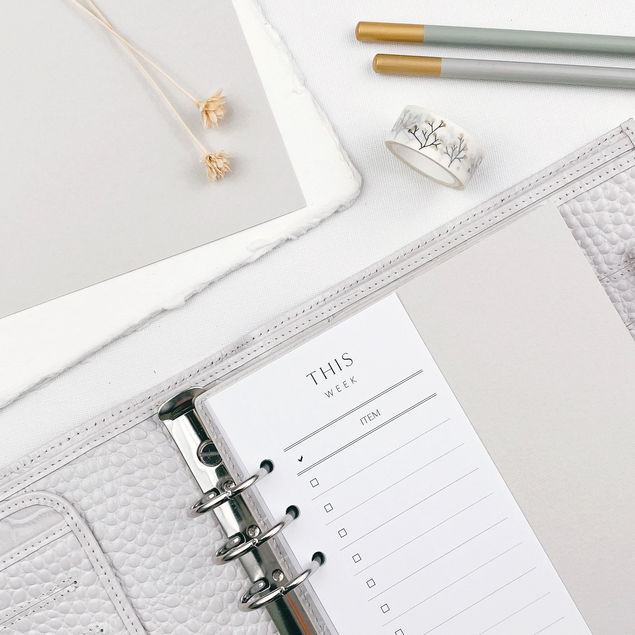 Slimline planner insert with 'This Week' checklist design, placed in an open 6 ring binder