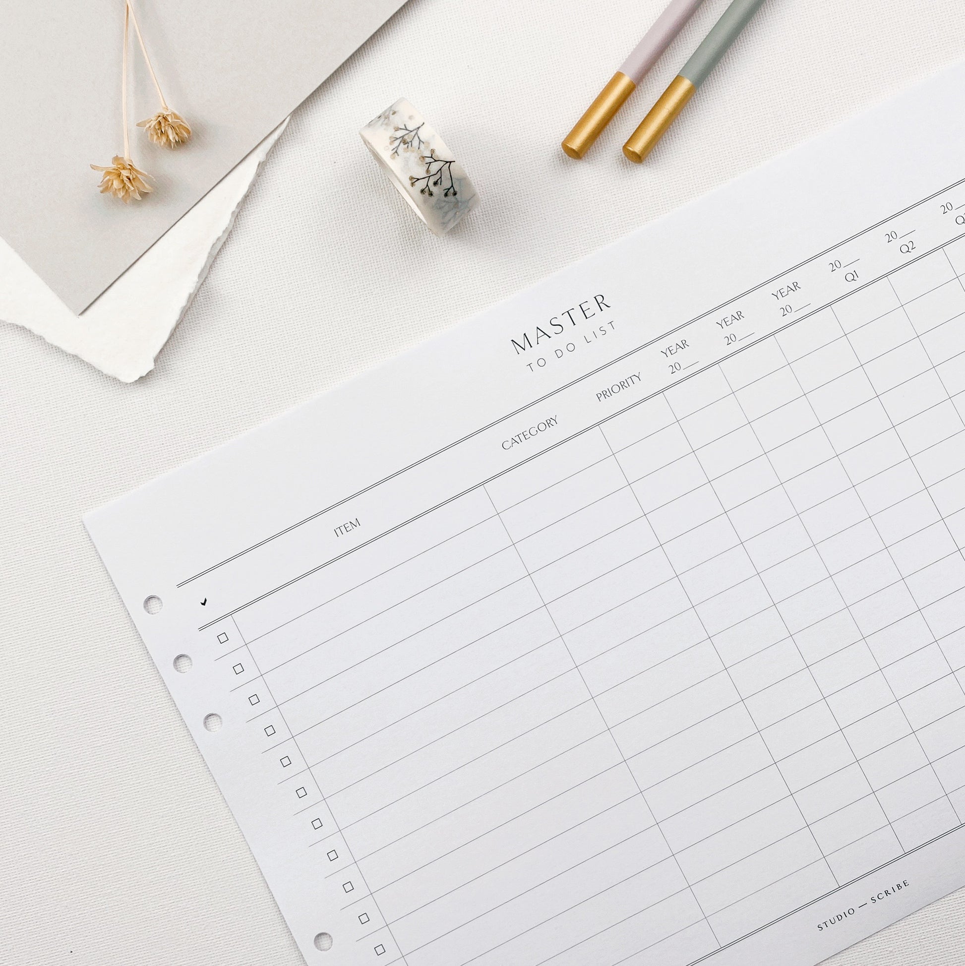 A4 master to do list planner page in landscape format, on a white surface surrounded by decorative items