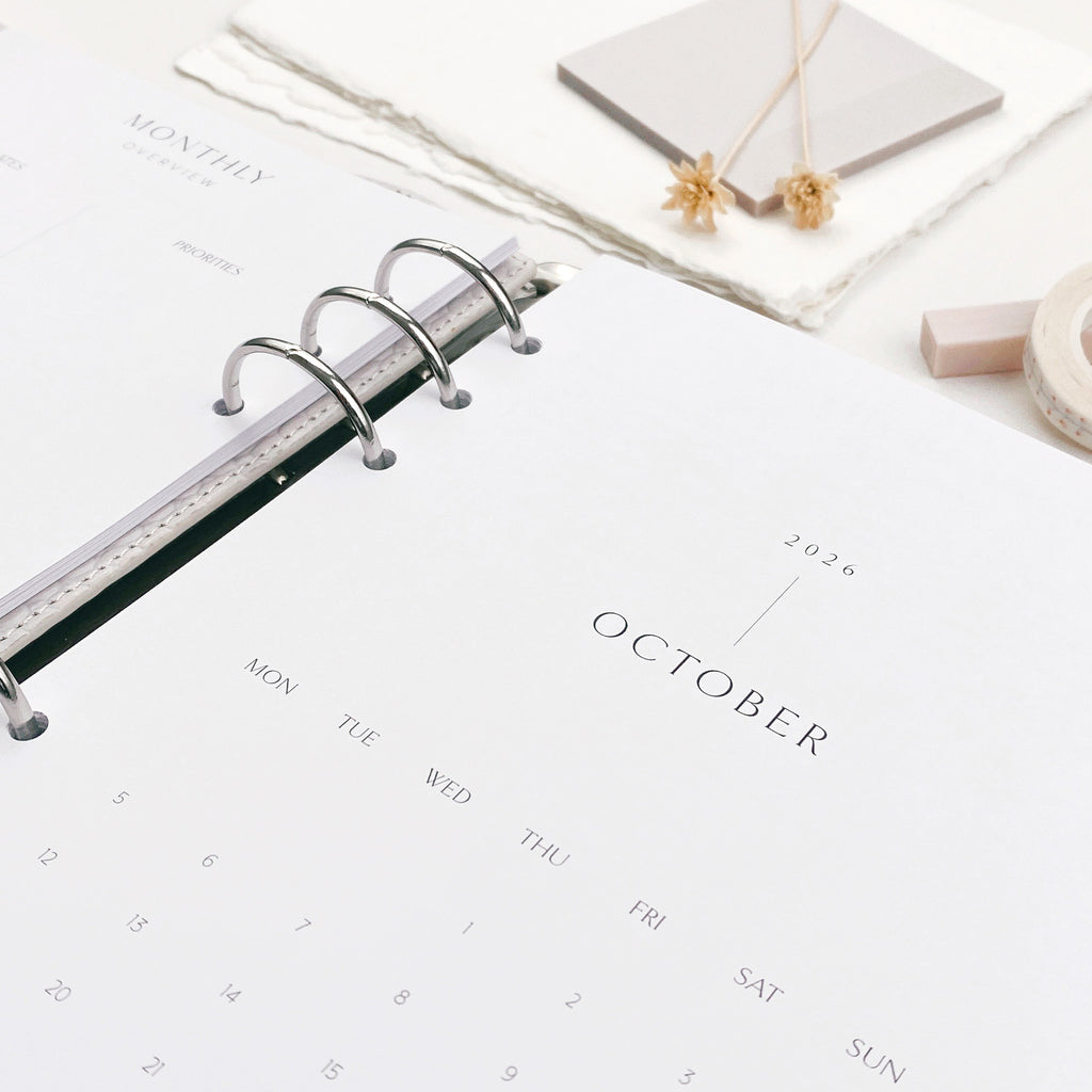 Calendar pages within a ring binder on a white surface