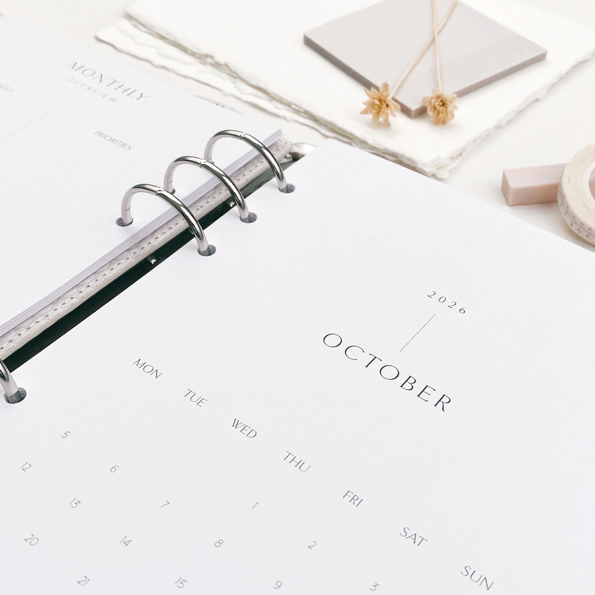 Calendar pages within a ring binder on a white surface