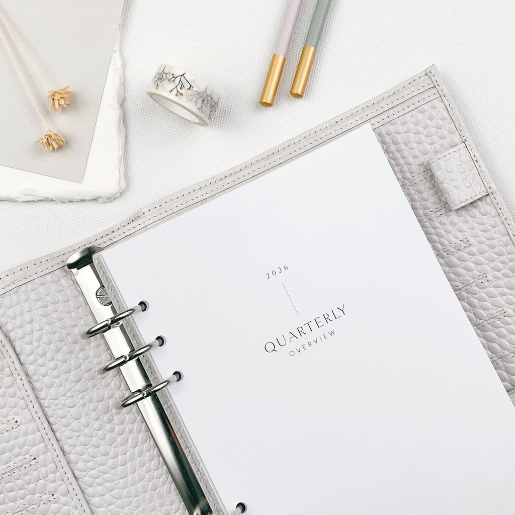 Planner pages with 'Quarterly Overview' design on a white surface with pencils and washi tape.