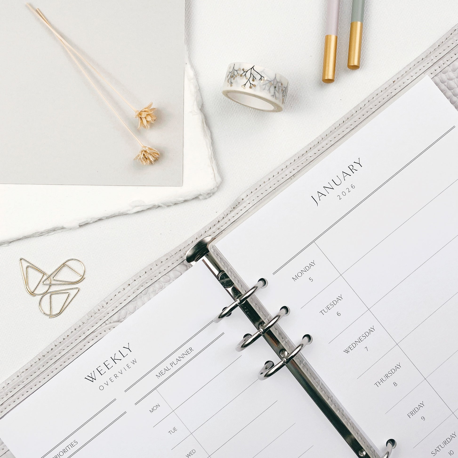Dashboard style planner layout with stationery items on a white surface