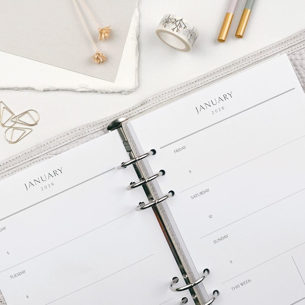 Open planner showing classic overview layout with decorative items on a white surface