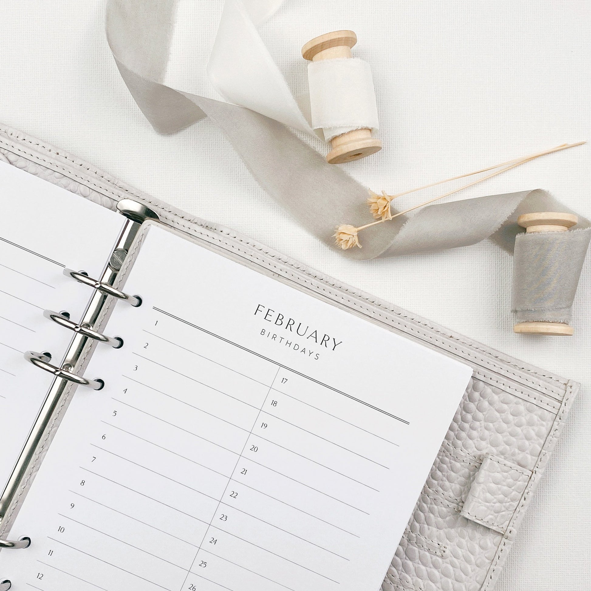 Open planner showing birthday reminder pages with decorative elements on a light background