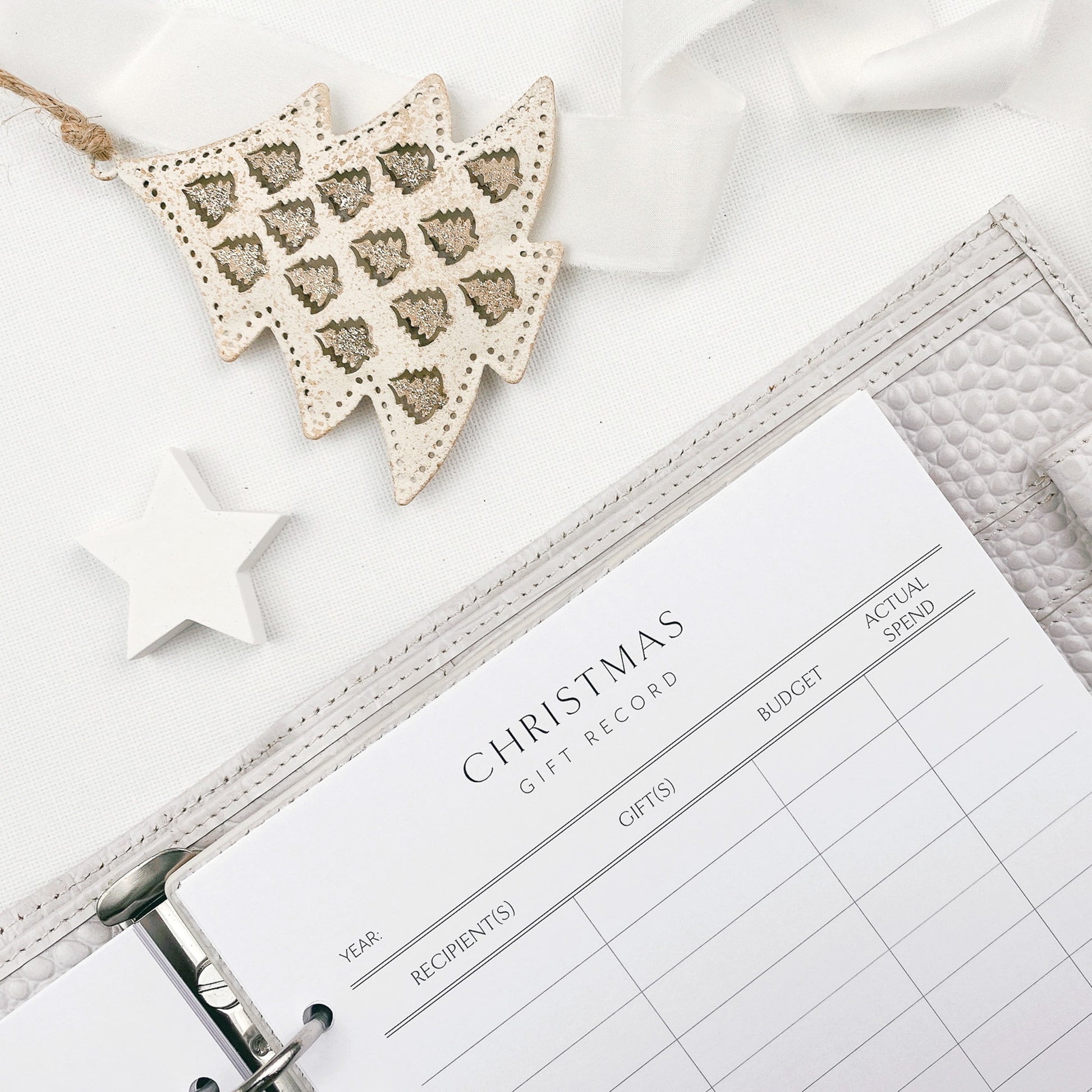 Christmas gift record sheet with decorative items on a white surface