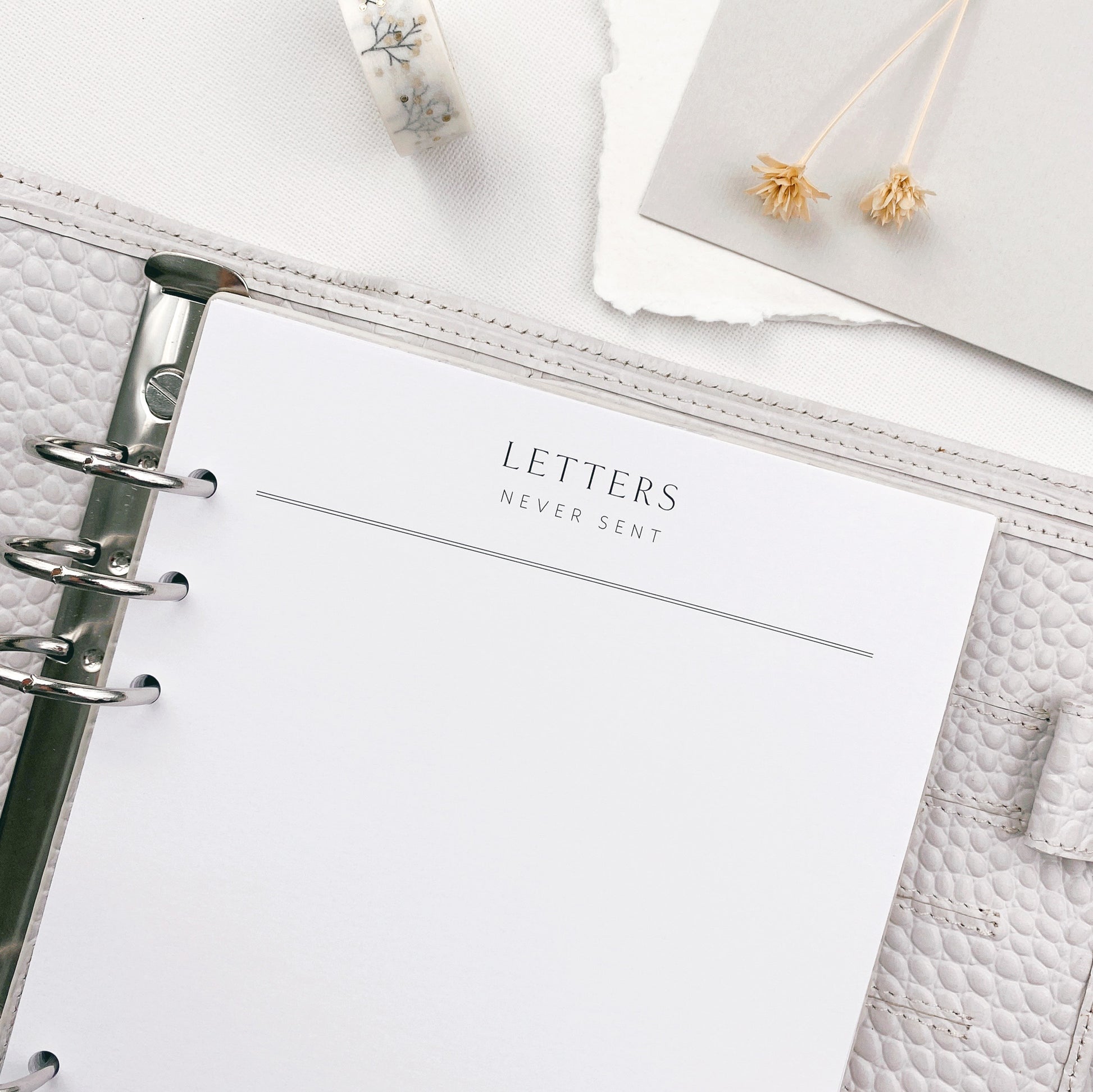 Planner with a Letters Never Sent refill page, surrounded by decorative items