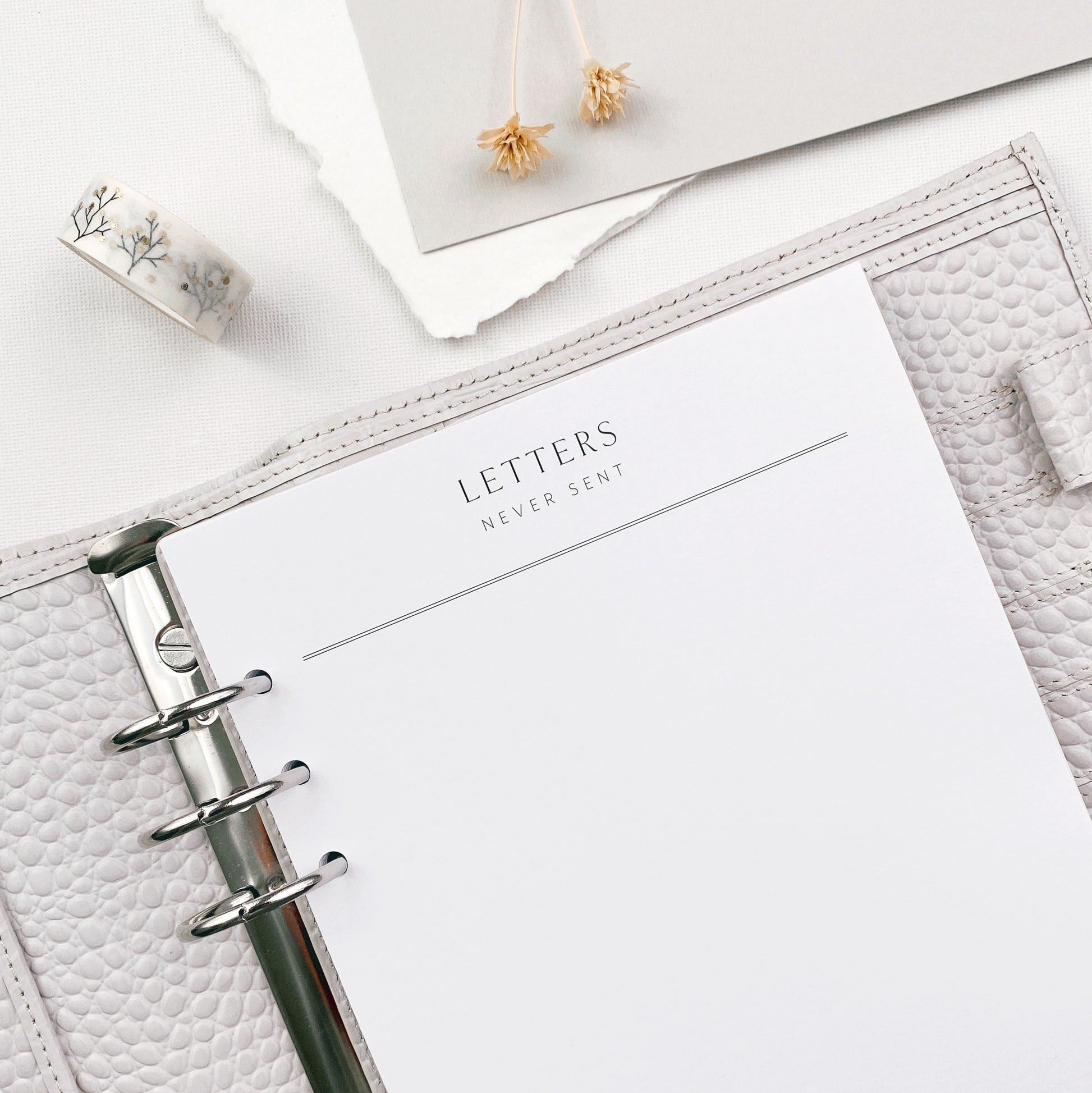 Planner with a Letters Never Sent refill page, surrounded by decorative items