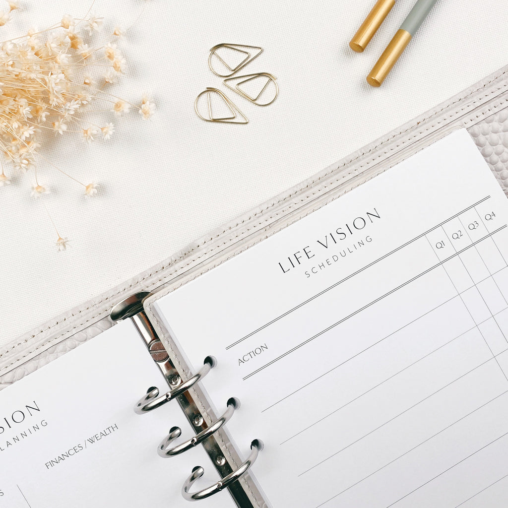 Life vision scheduling planner with decorative elements on a white surface