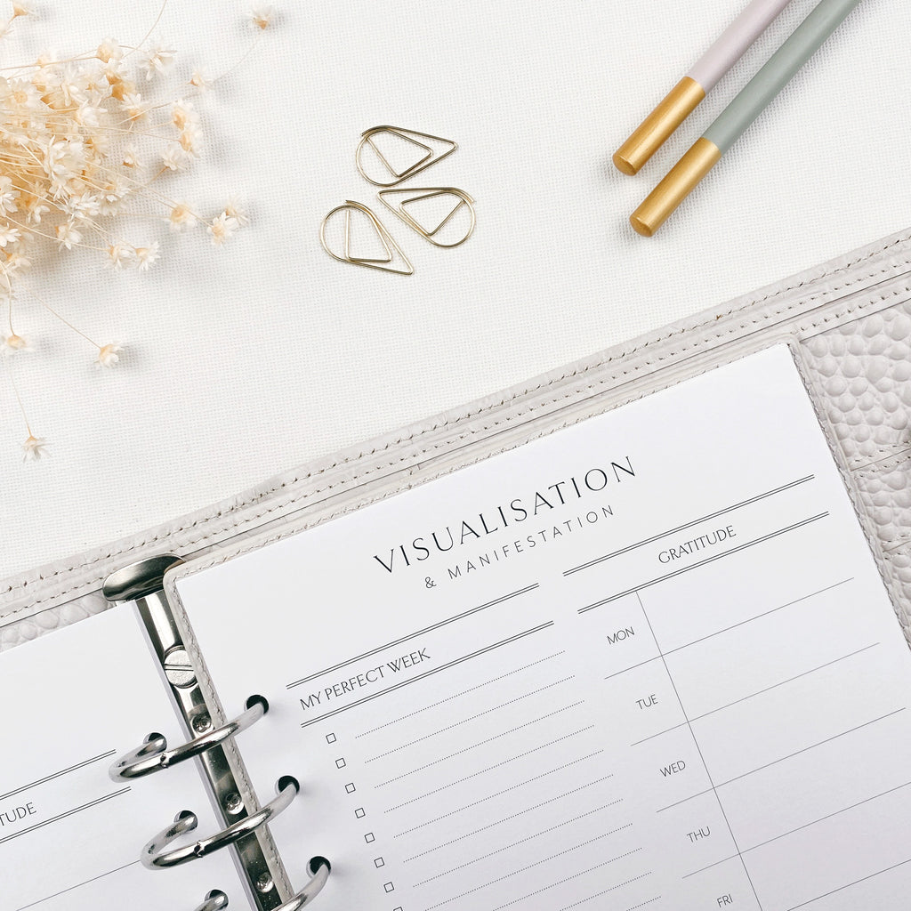 Planner with 'Visualisation & Manifestation' section on a white surface with decorative elements.