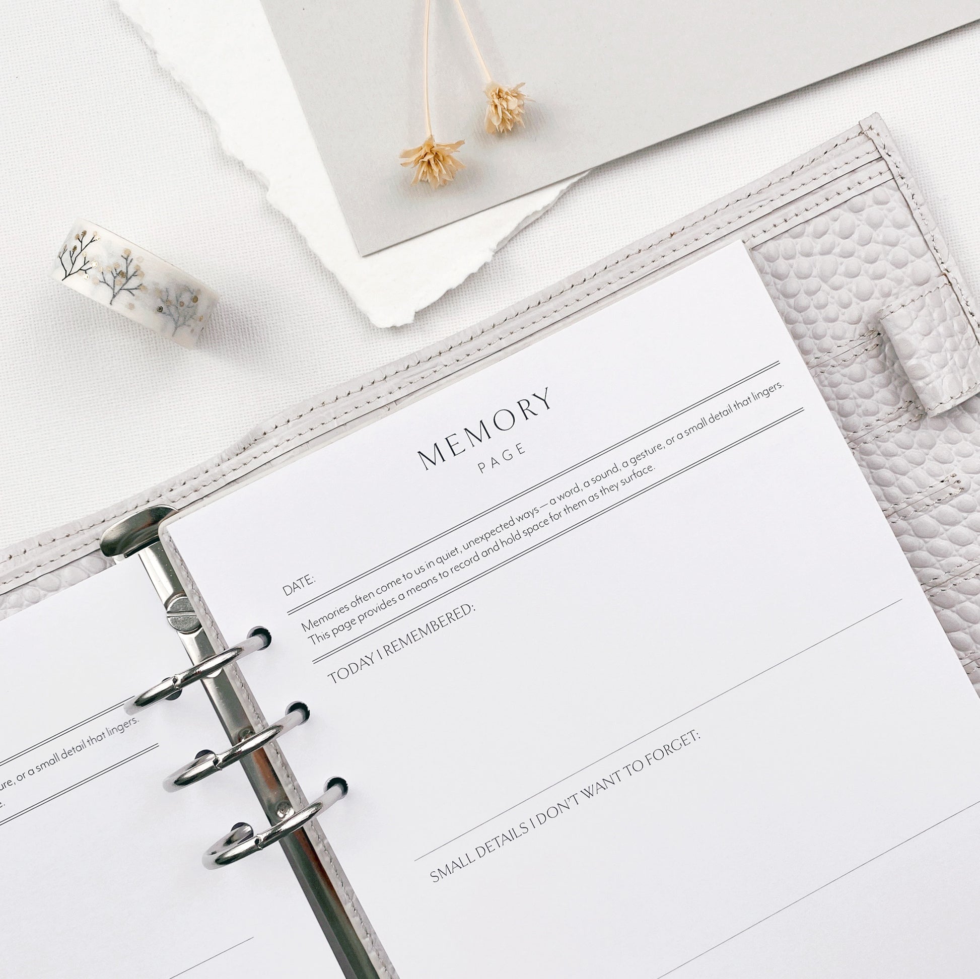 Planner open to a memory page refill, surrounded by decorative items.