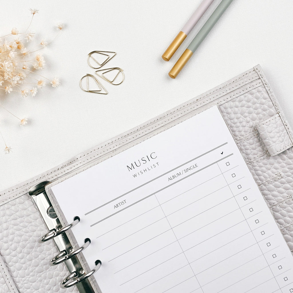 Music wishlist planner pages with stationery items on a light surface