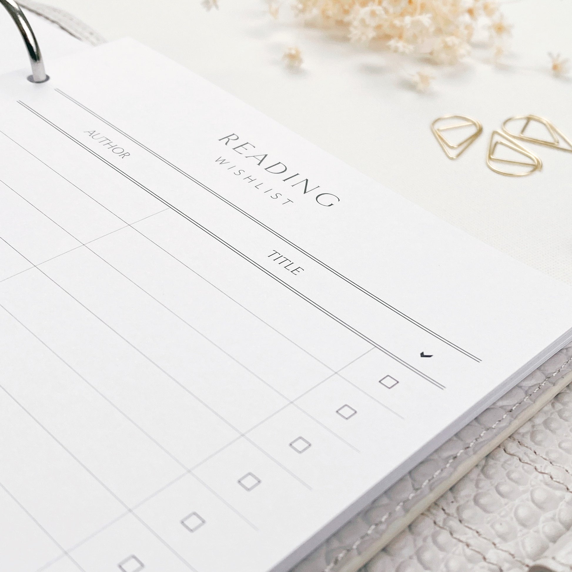 Reading wishlist page in a planner with decorative elements