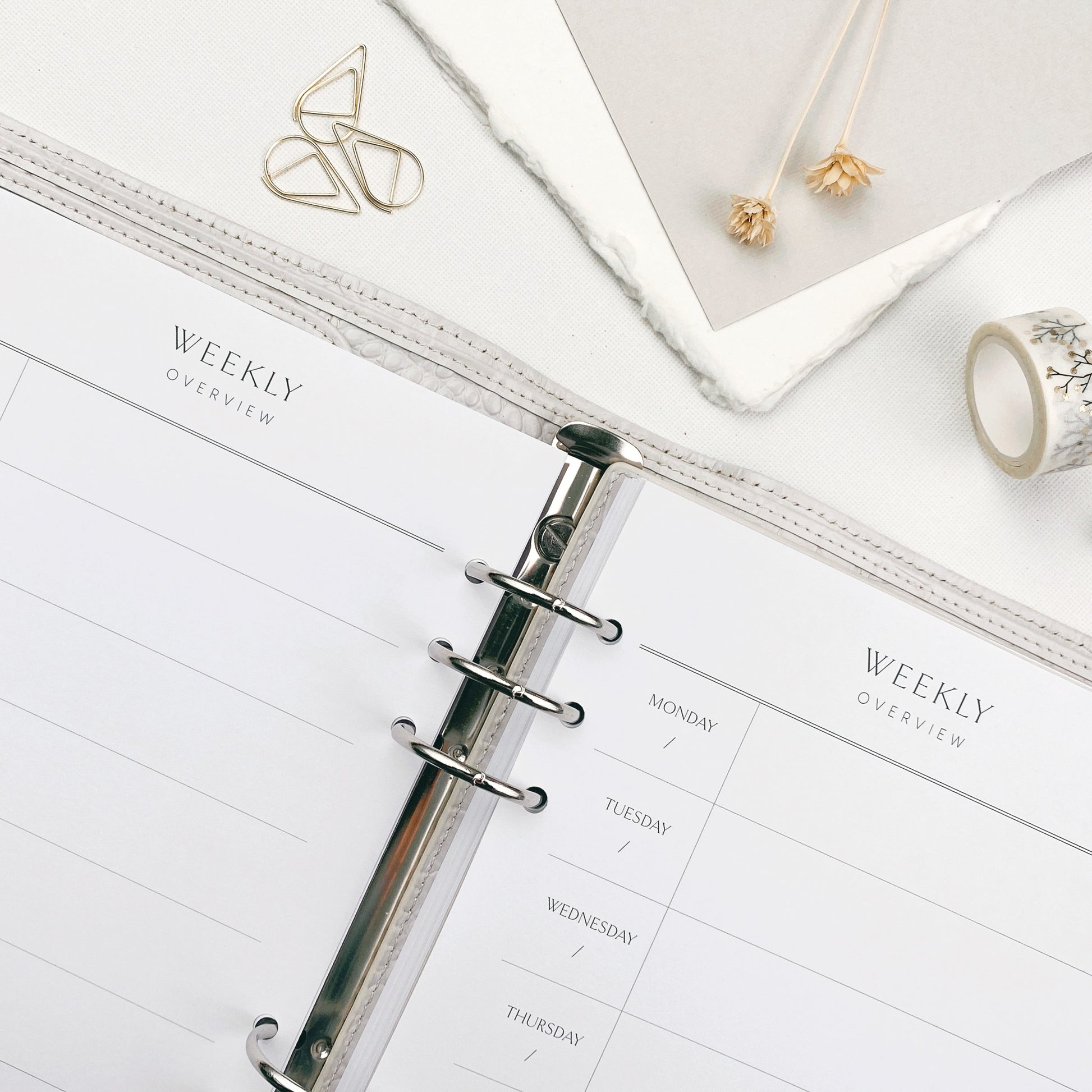 Open planner with weekly overview on a white surface