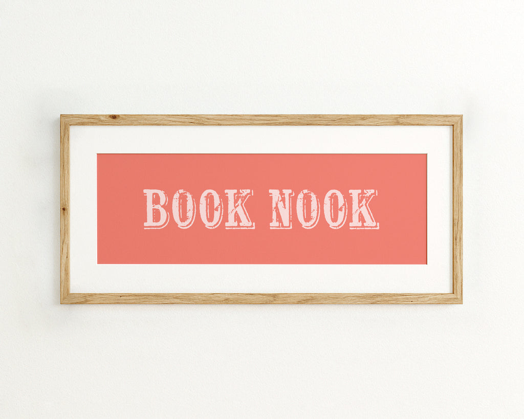 Framed artwork with 'BOOK NOOK' text on a coral background