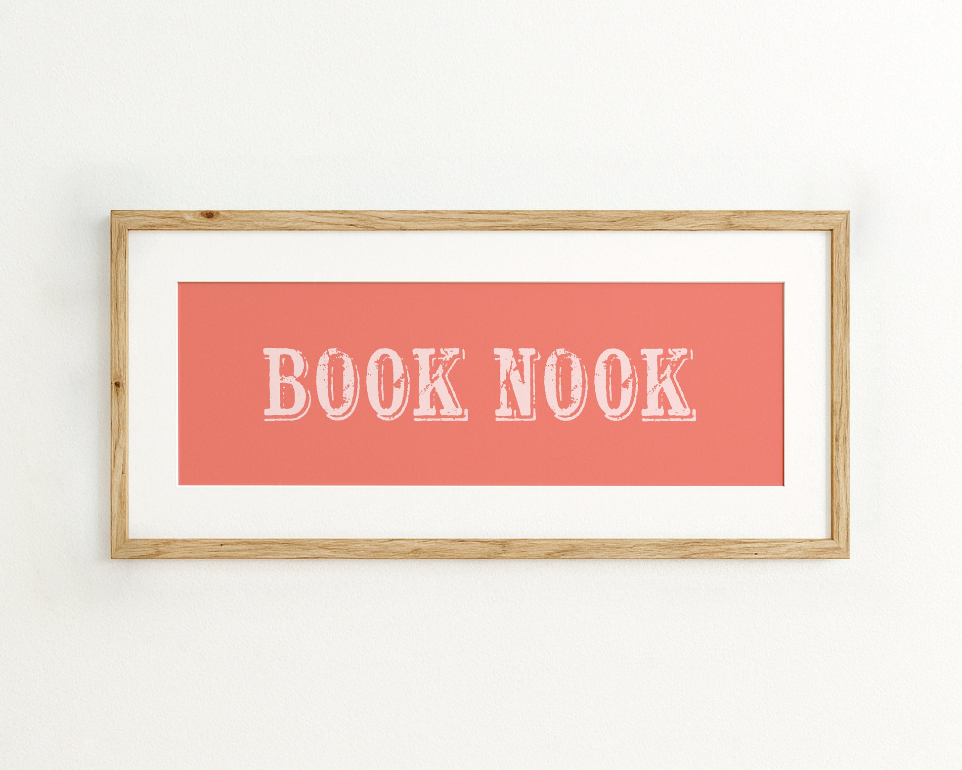 Framed artwork with 'BOOK NOOK' text on a coral background