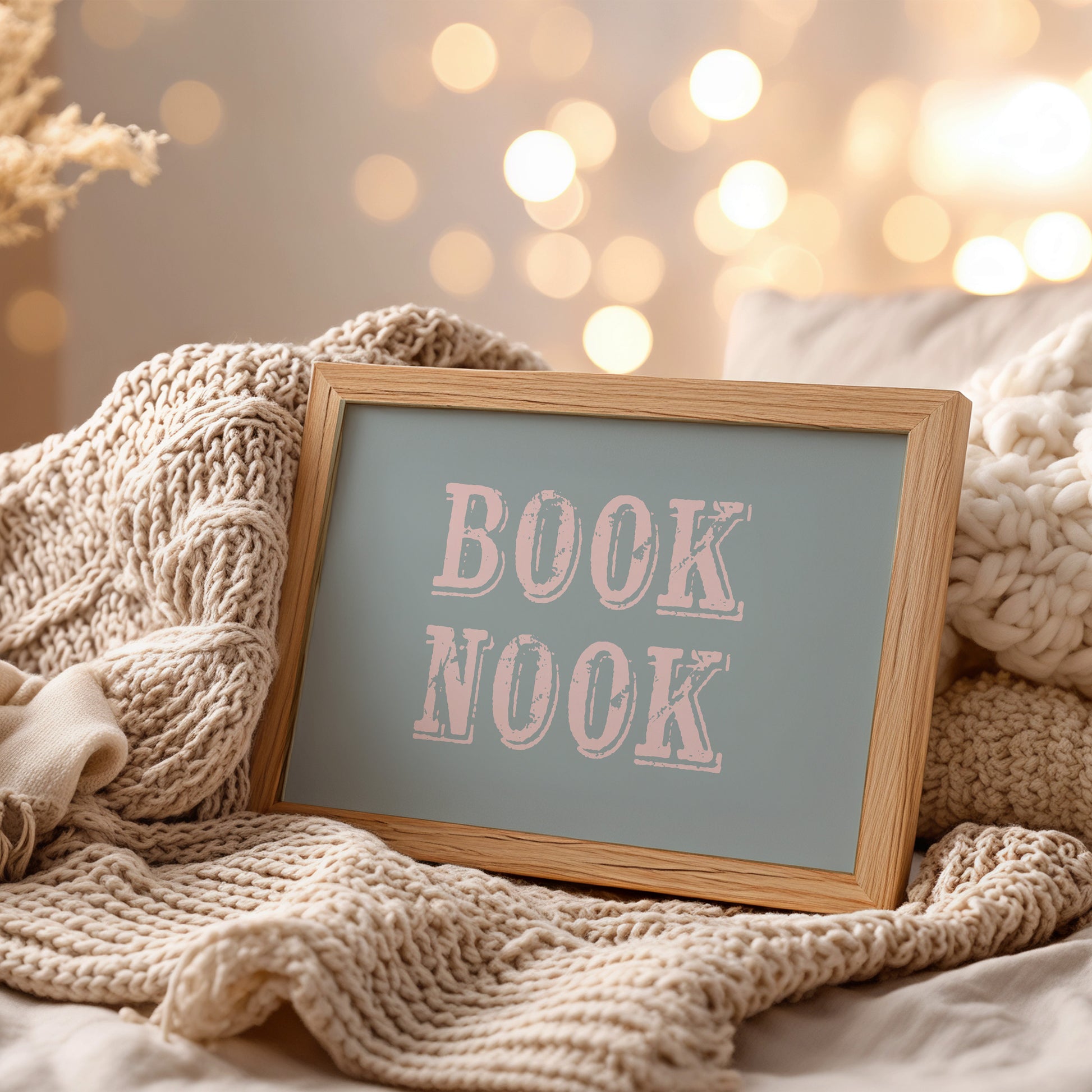 Dopamine decor wall art print with 'BOOK NOOK' text on a cozy setting with knitted textures and soft lighting.