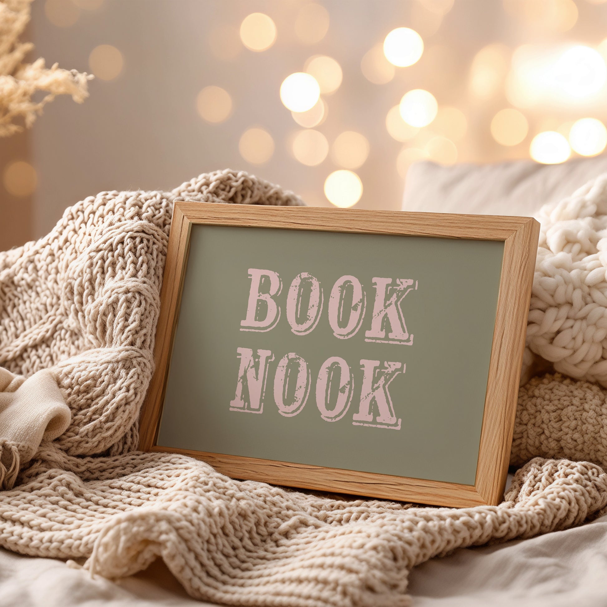 Decorative sign with 'BOOK NOOK' text on a cozy setting with knitted textures and soft lighting.