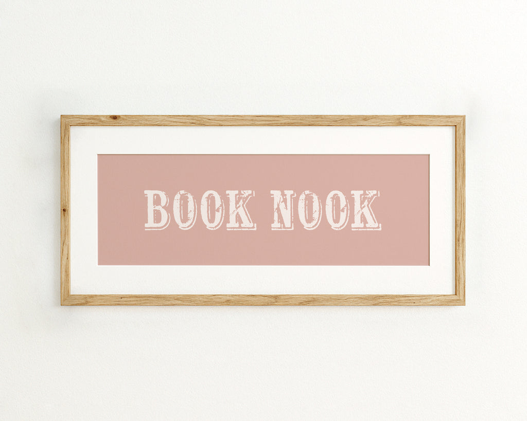 Framed wall art with 'BOOK NOOK' text on a pink background