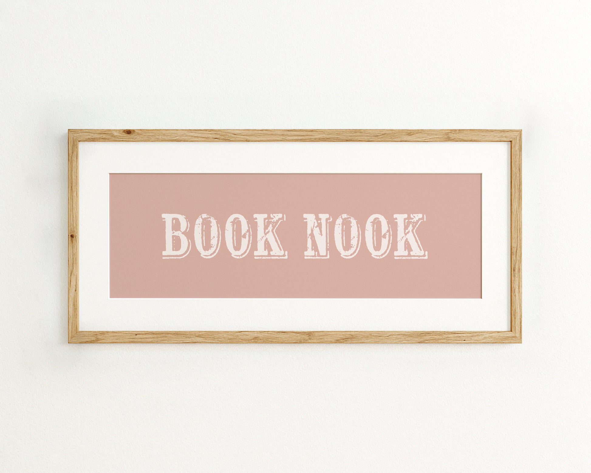 Framed wall art with 'BOOK NOOK' text on a pink background