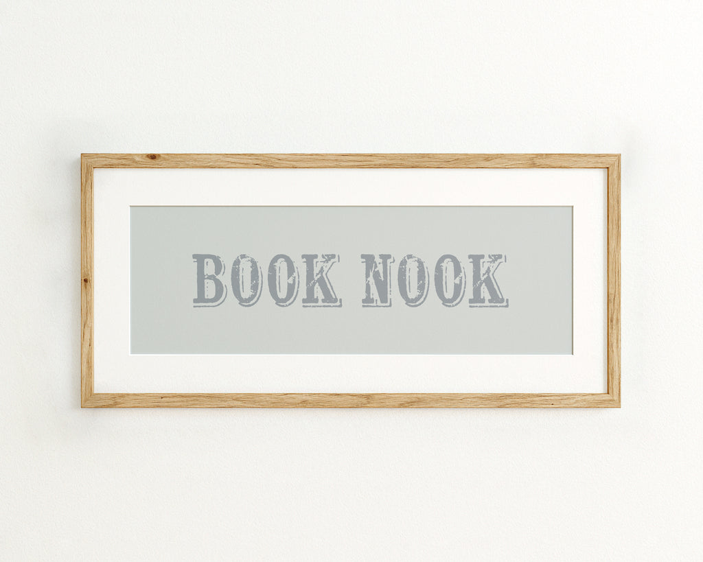 Framed wall art with 'BOOK NOOK' text on a light blue background