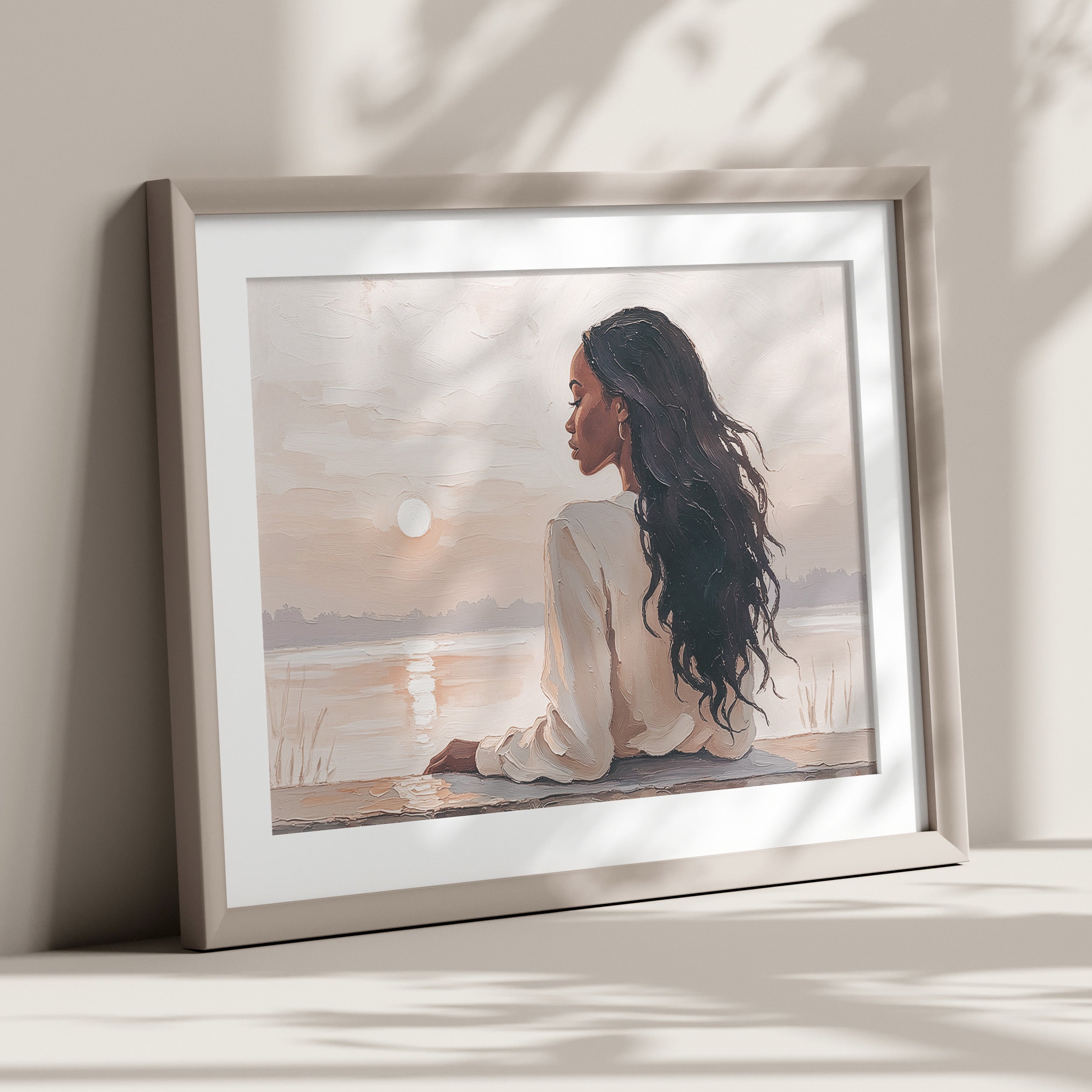 Artwork of a woman resting by the water with a sunset.