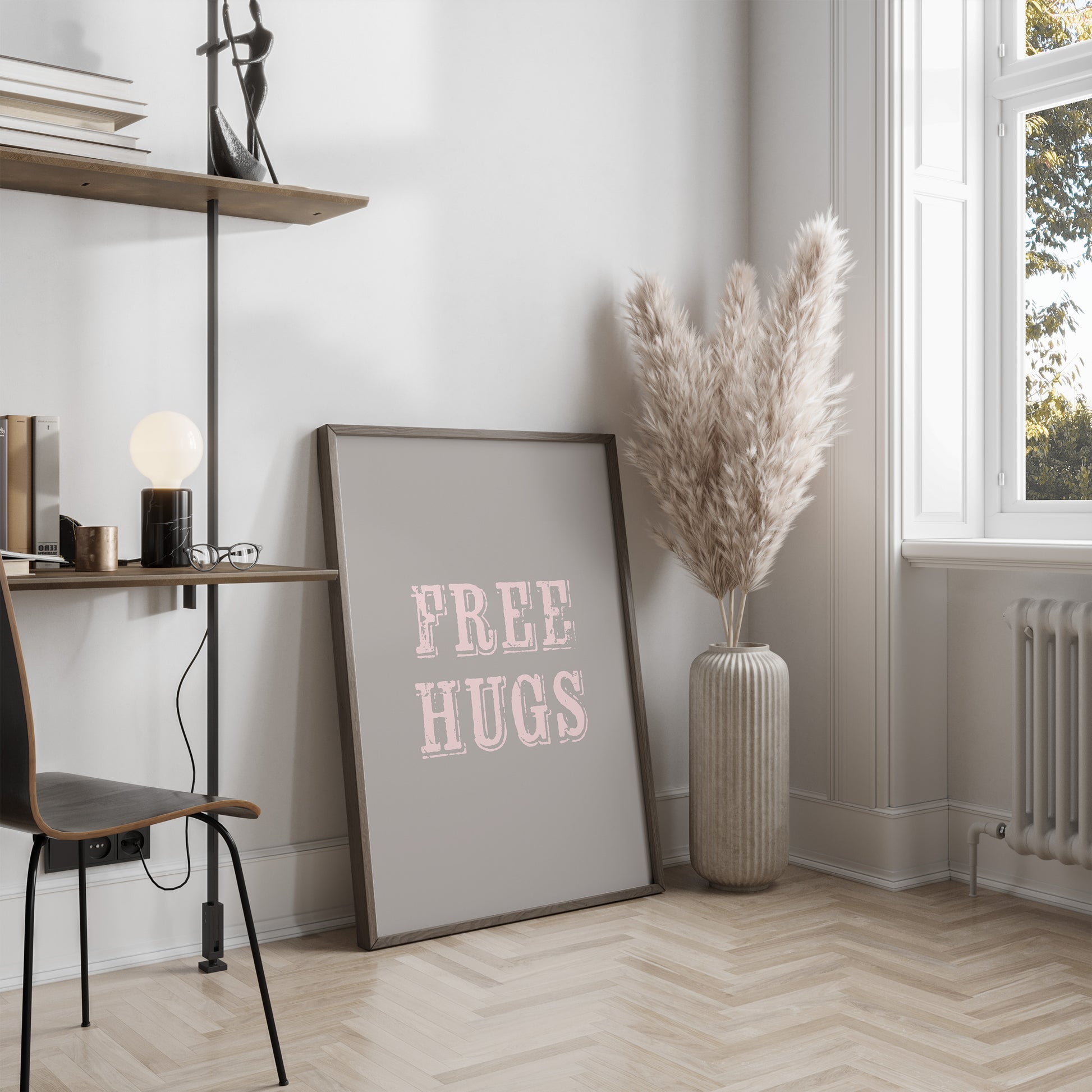 Room interior with a 'FREE HUGS' poster, vase with dried plants, and desk.