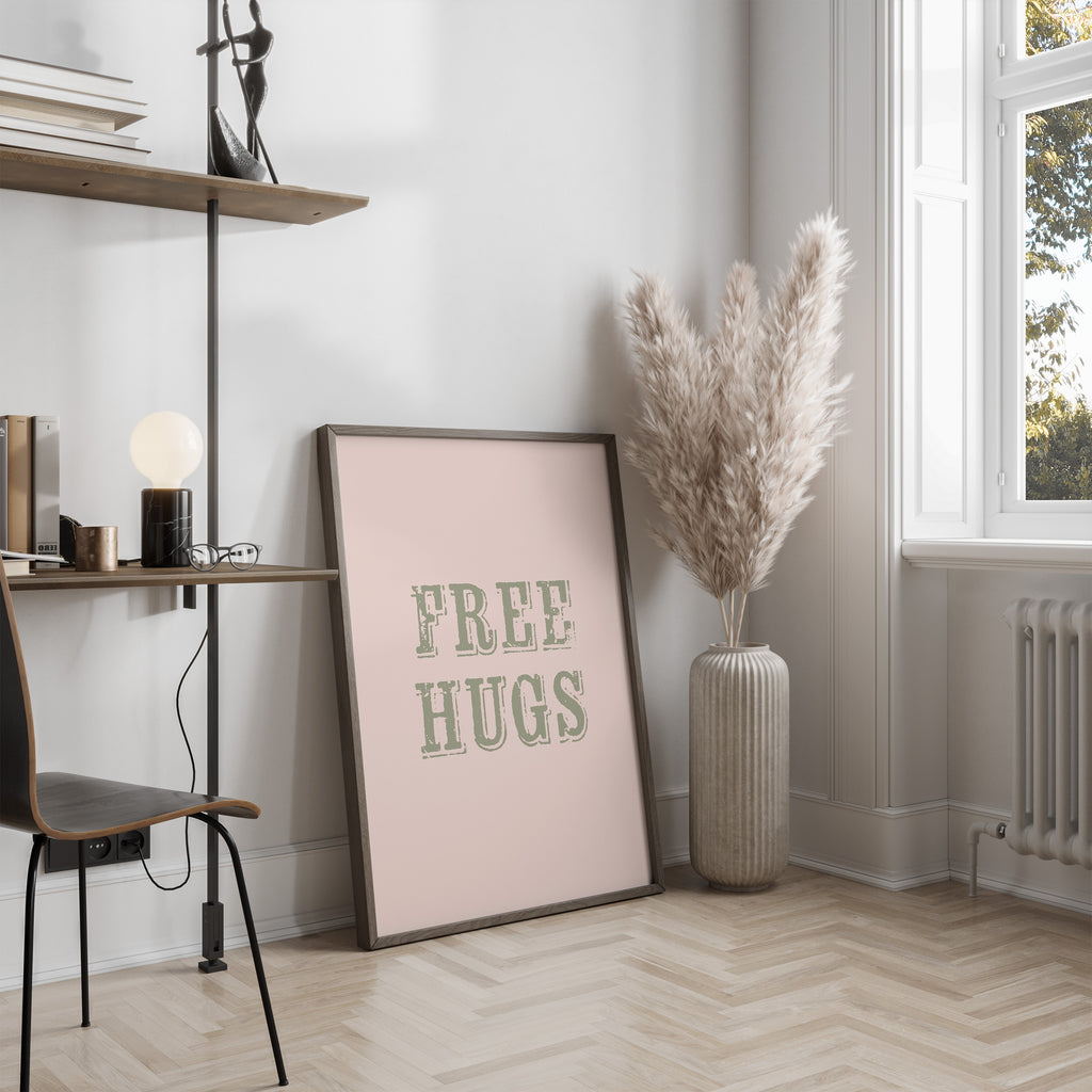 Framed 'FREE HUGS' poster on a wall in a modern room with decor elements.