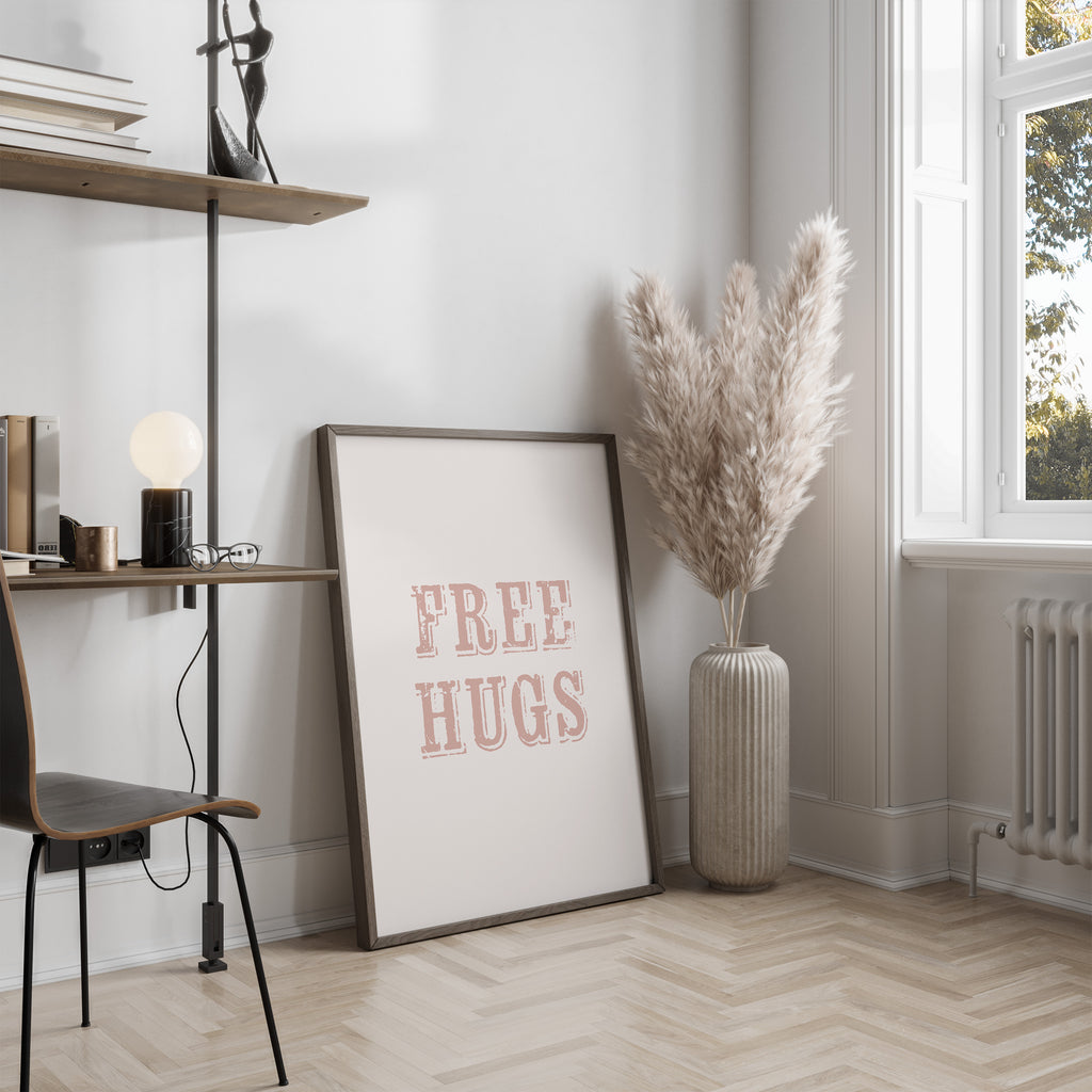 Room interior with a 'FREE HUGS' poster, vase with dried plants, and desk.