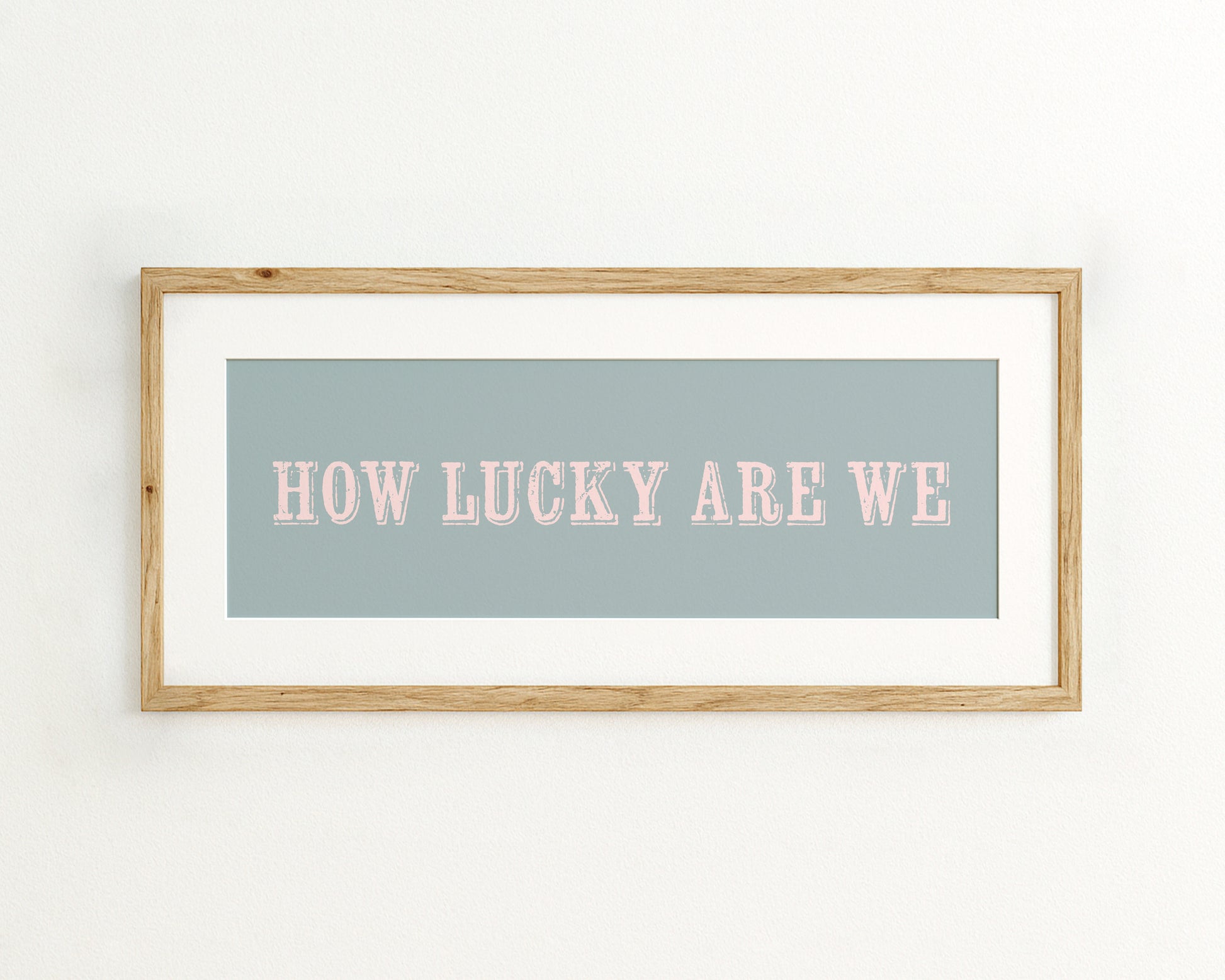 Framed print with 'HOW LUCKY ARE WE' text on a light blue background