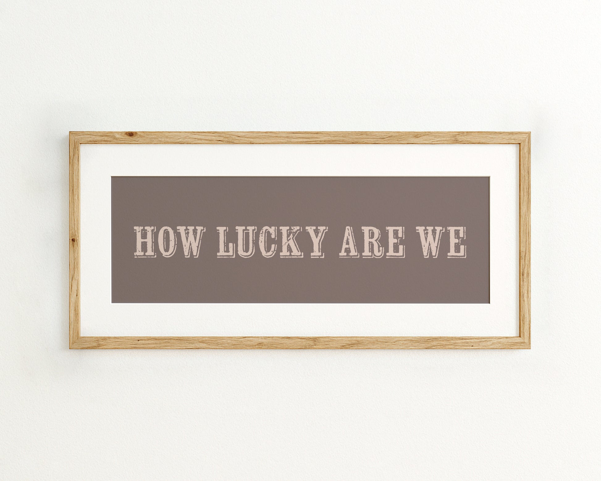 Framed print with 'HOW LUCKY ARE WE' text on a mocha brown background