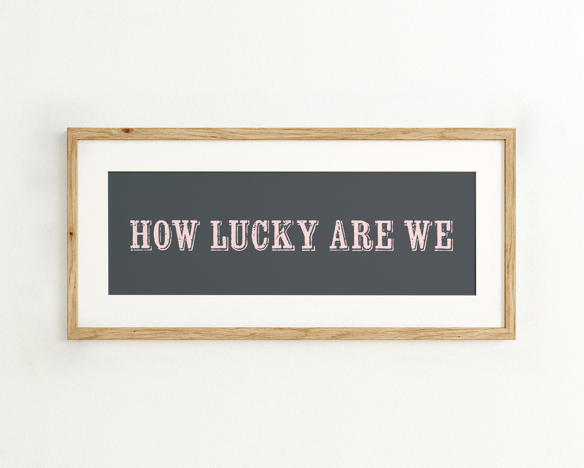 Framed artwork with 'HOW LUCKY ARE WE' text on a dark blue background