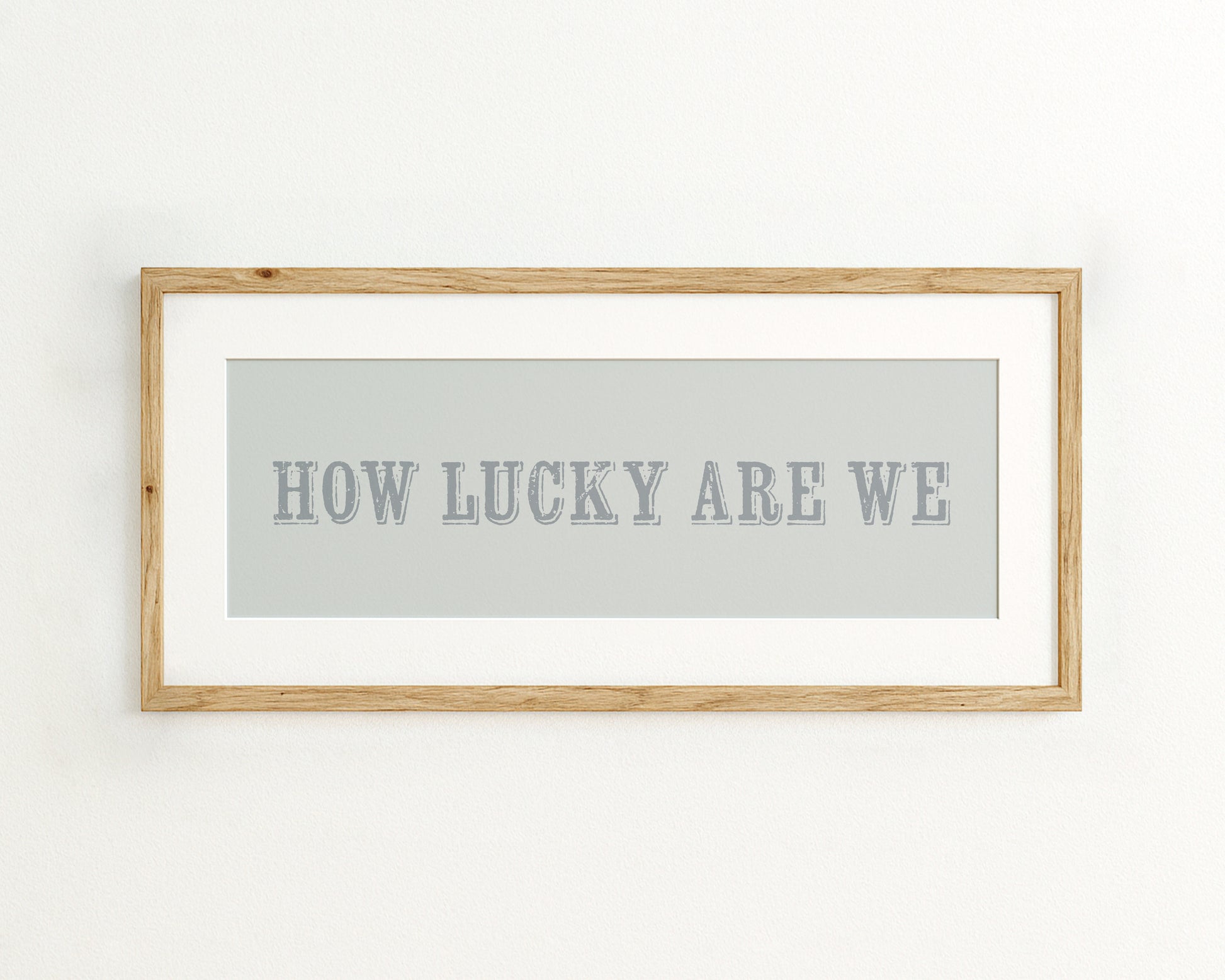 Framed print with 'HOW LUCKY ARE WE' text on a light blue background