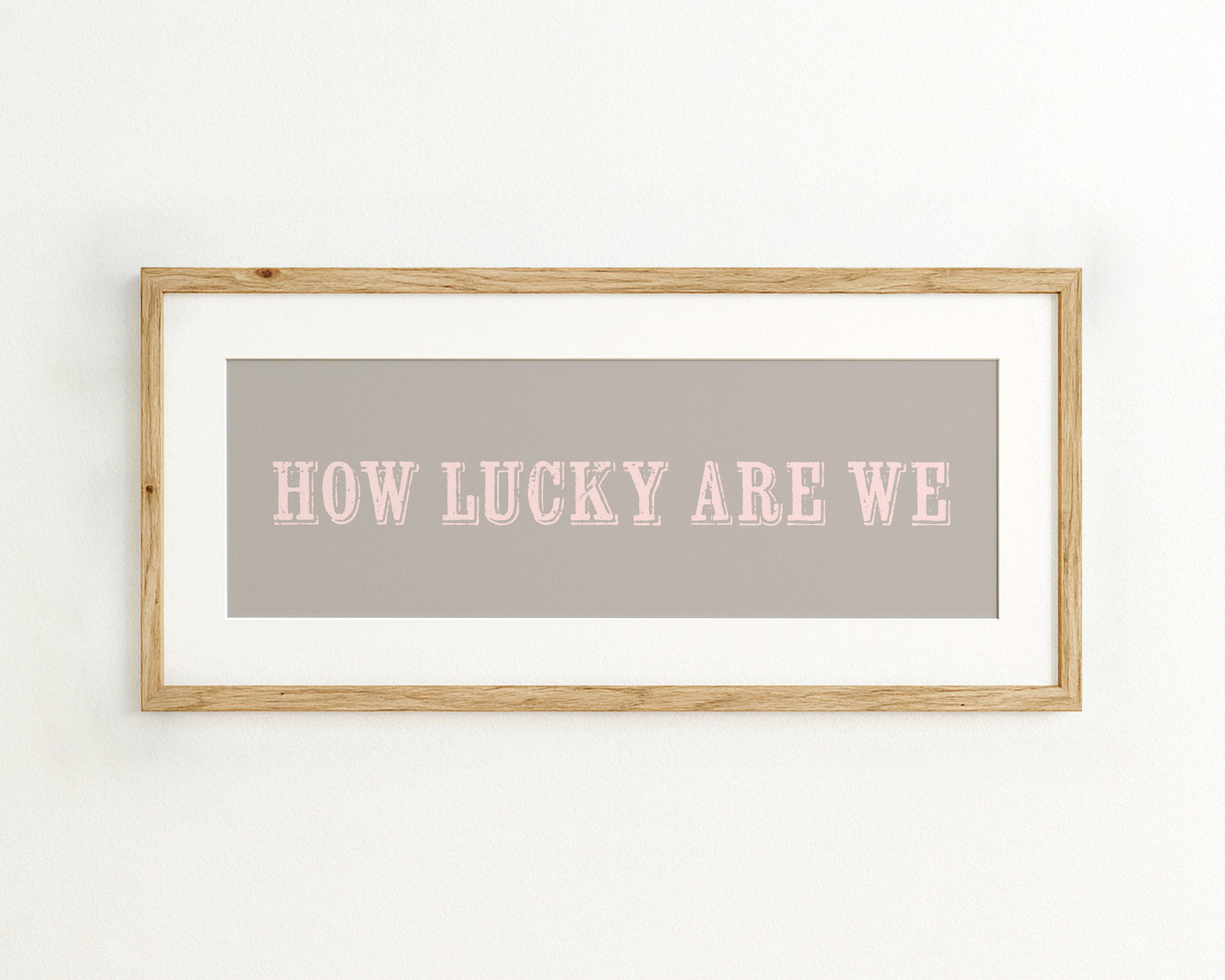 Framed print with 'HOW LUCKY ARE WE' text on a grey background