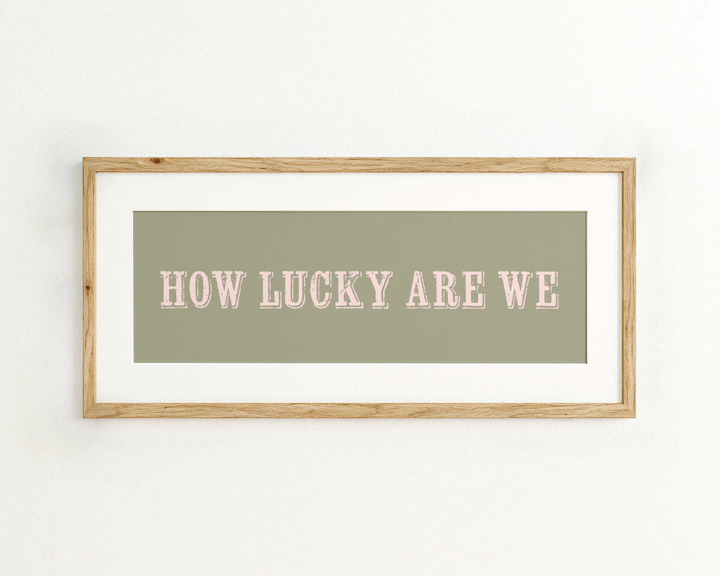 Framed print with 'HOW LUCKY ARE WE' text on a green background