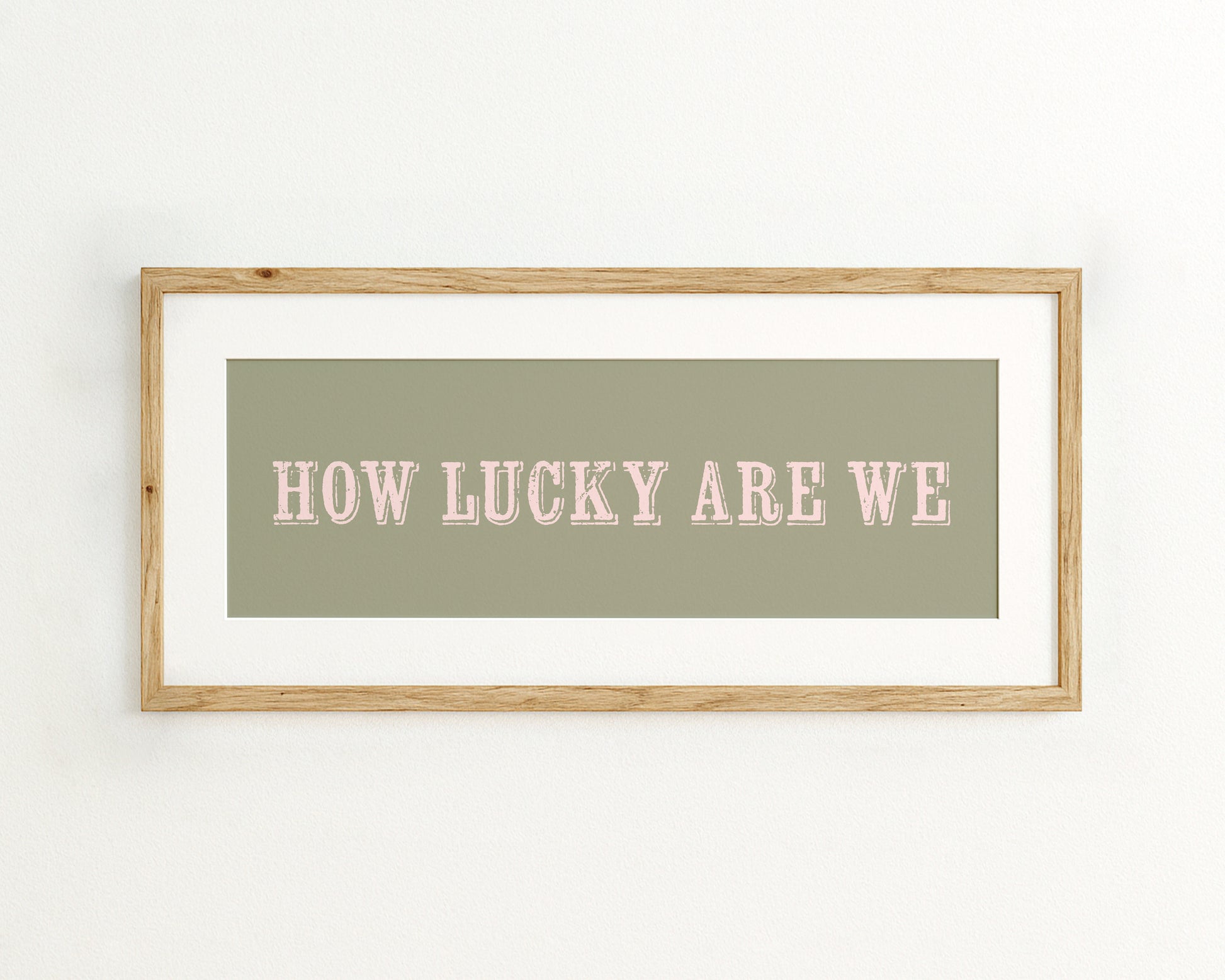 Framed print with 'HOW LUCKY ARE WE' text on a green background