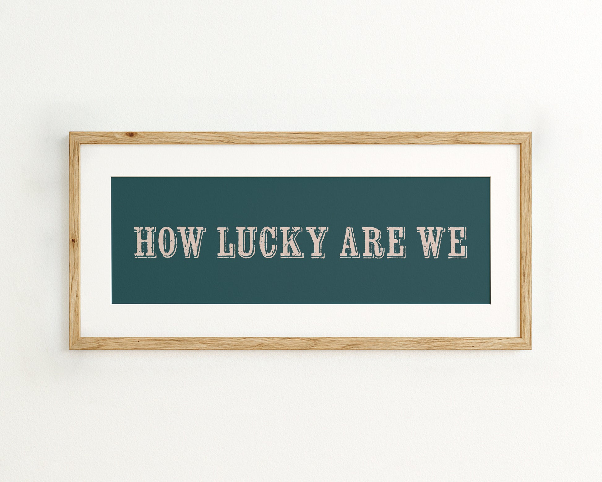 Framed print with 'HOW LUCKY ARE WE' text on a teal background