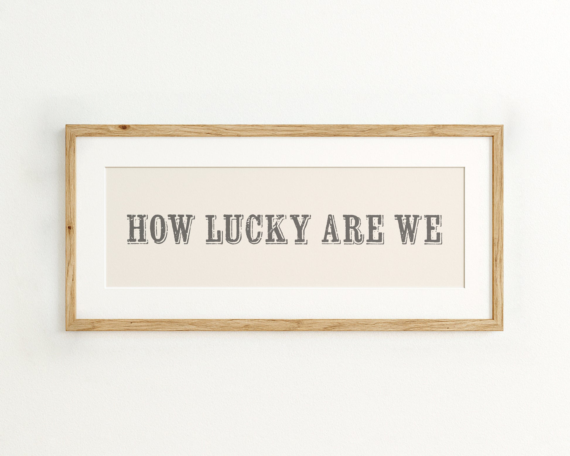Framed print with 'HOW LUCKY ARE WE' text on a cream background