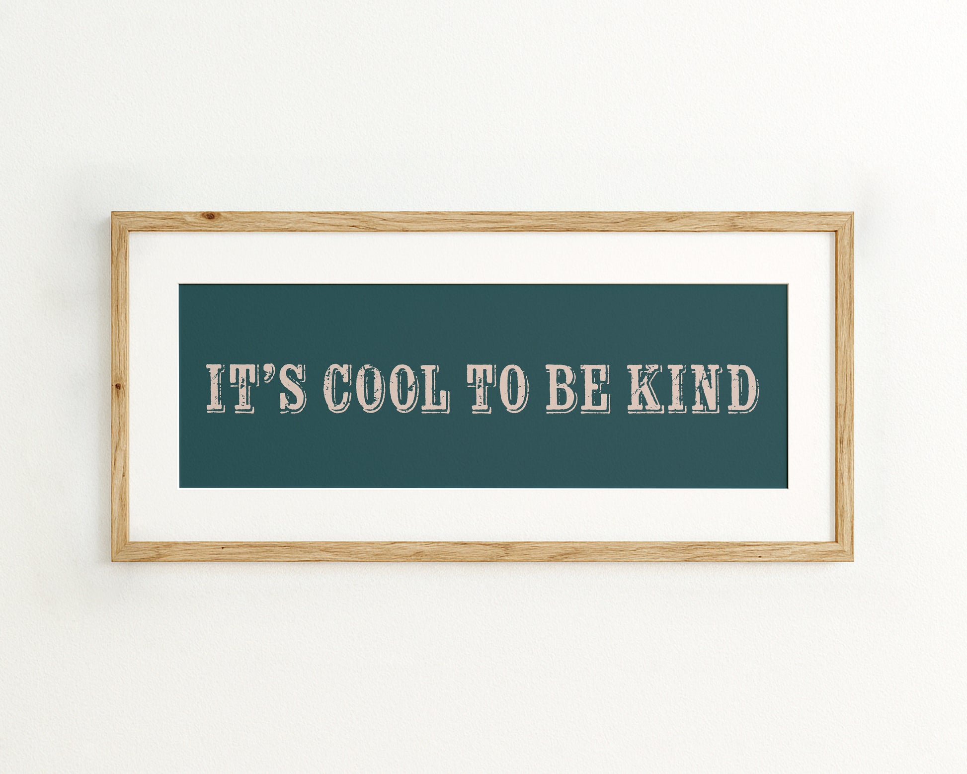 Framed artwork with 'It's Cool to be Kind' text on a teal background