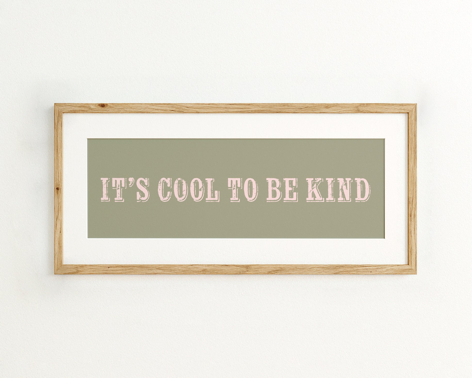Framed print with 'It's cool to be kind' text on a green background