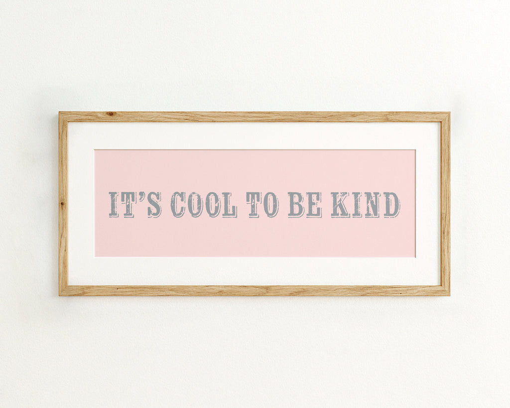 Framed print with 'It's cool to be kind' text on a pink background
