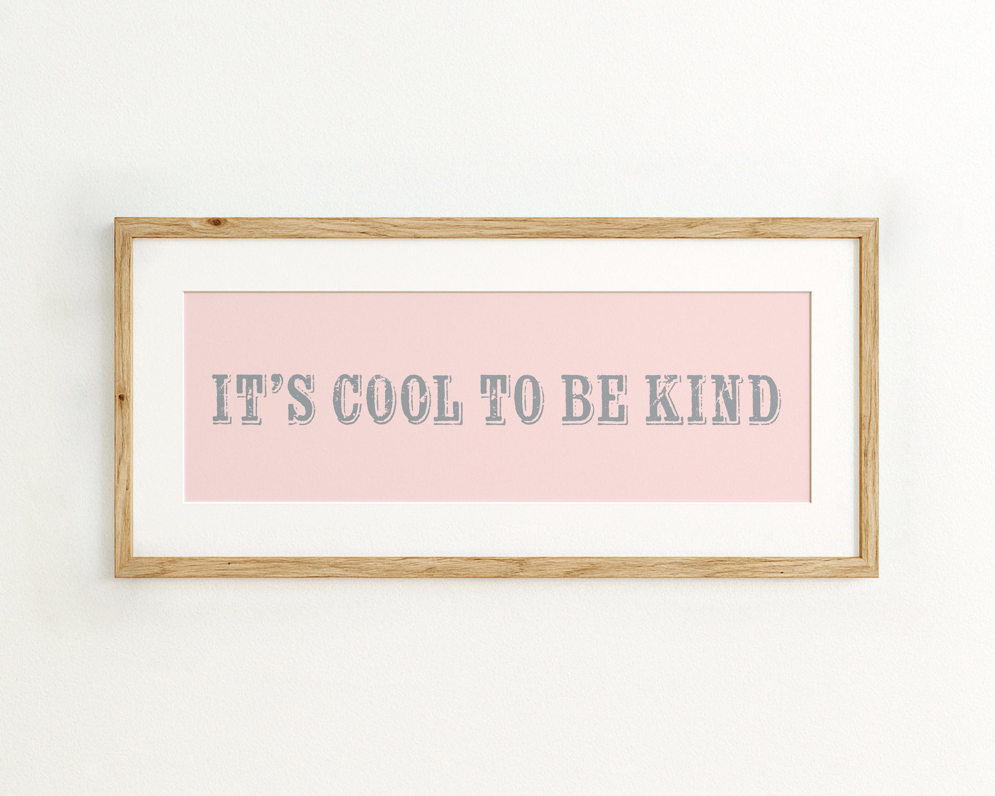 Framed print with 'It's cool to be kind' text on a pink background