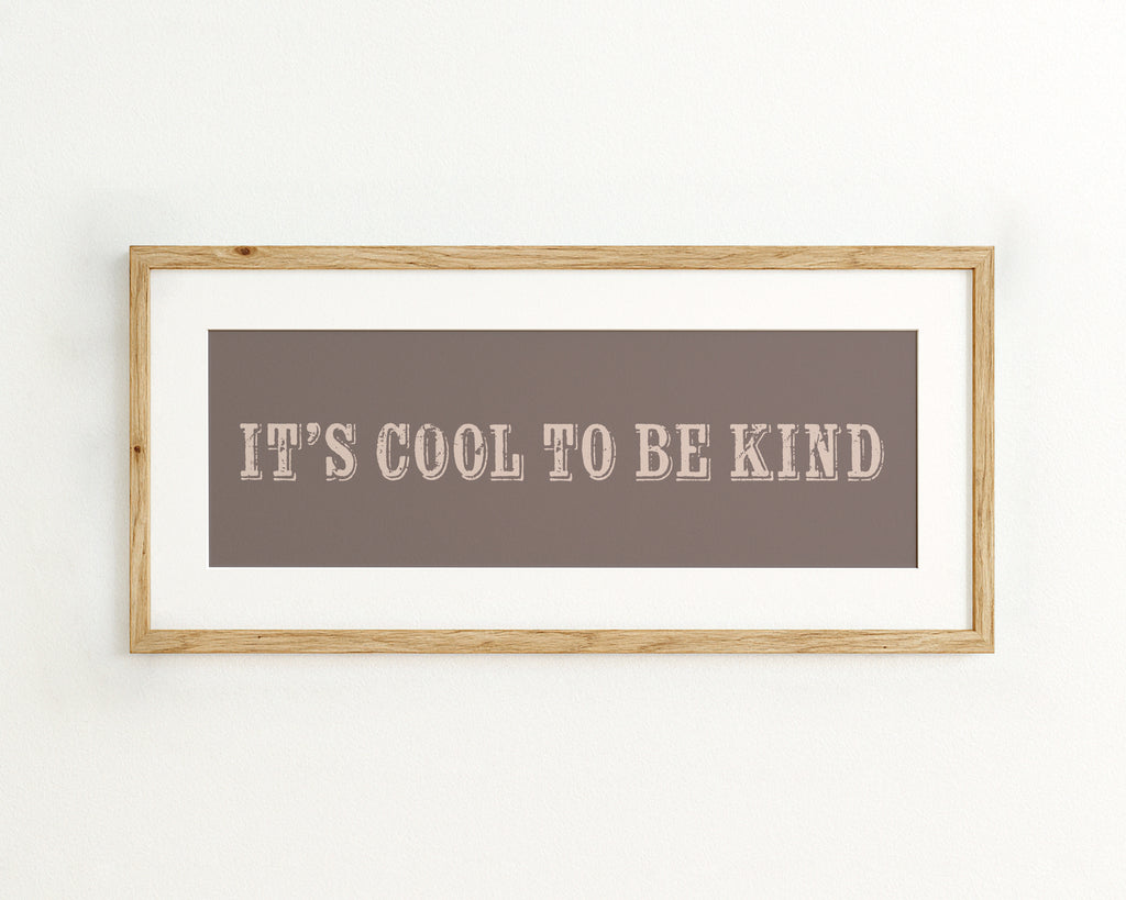 Framed quote 'IT'S COOL TO BE KIND' on a brown background