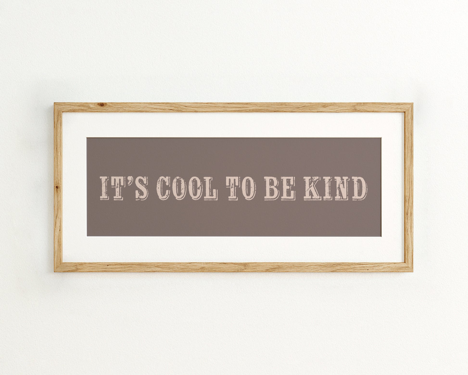 Framed quote 'IT'S COOL TO BE KIND' on a brown background