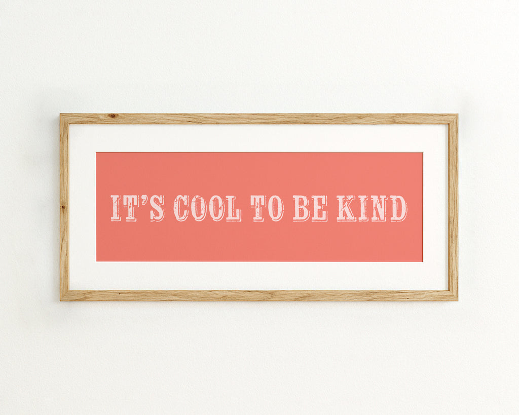 Framed poster with 'It's Cool to be Kind' text on a coral background