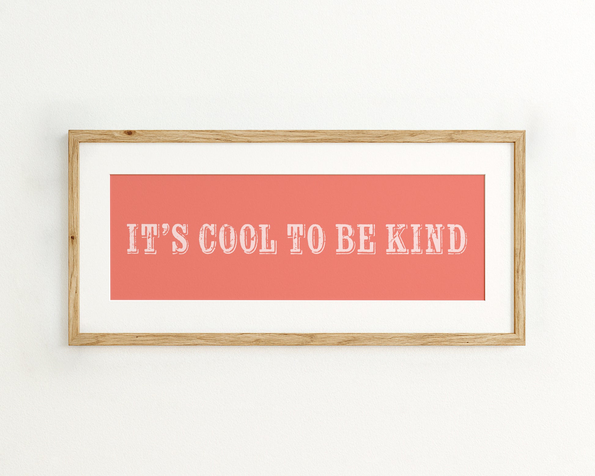 Framed poster with 'It's Cool to be Kind' text on a coral background