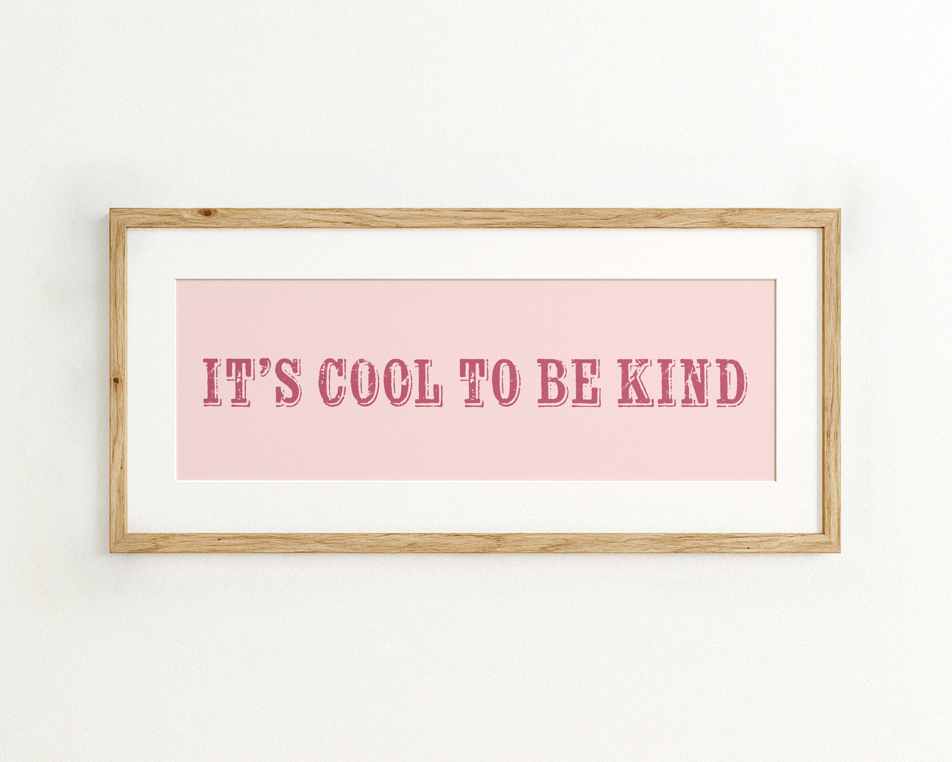 Framed poster with 'It's cool to be kind' text on a pink background