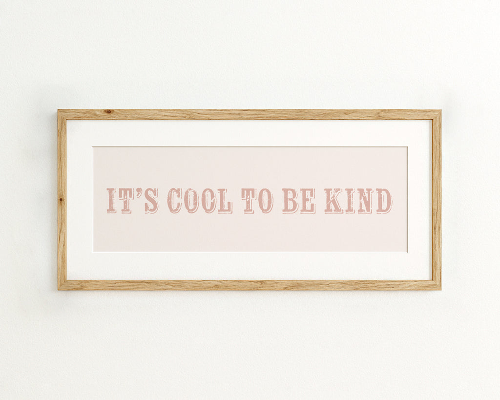 Framed print with 'It's cool to be kind' text on a light pink background