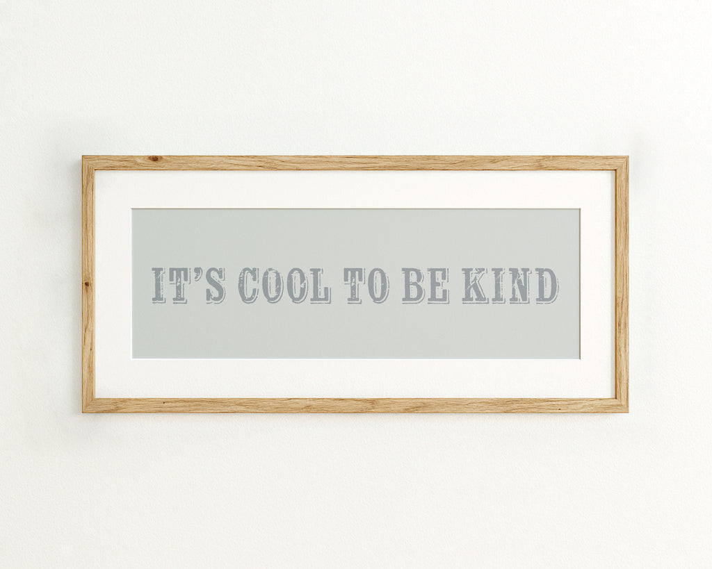 Framed quote 'IT'S COOL TO BE KIND' on a light blue background