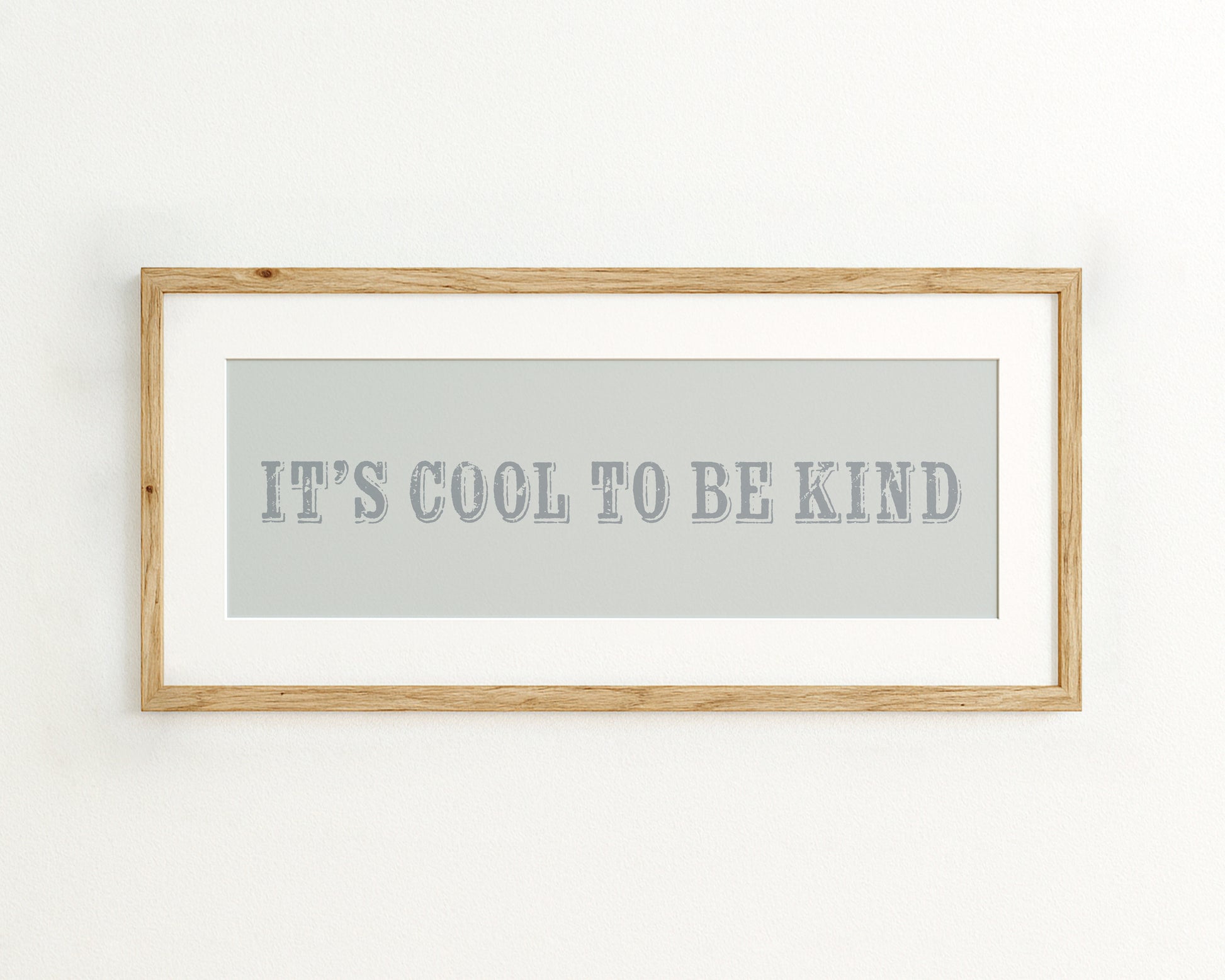 Framed quote 'IT'S COOL TO BE KIND' on a light blue background