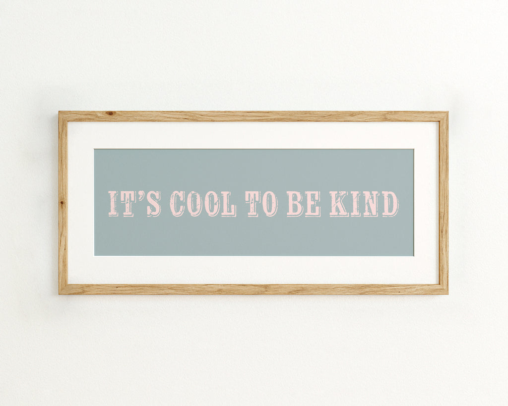 Framed print with 'It's cool to be kind' text on a light blue background